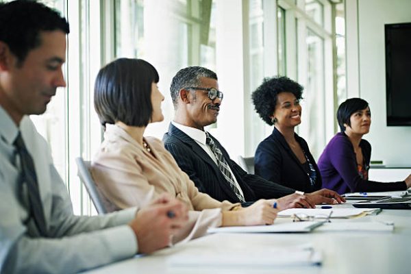 Group of coworkers in discussion at conference table smiling